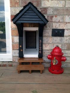 a red fire hydrant sitting next to a dog house