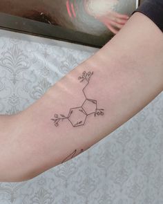 a woman's arm with a tattoo on it that has an image of a flower