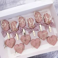 pink and gold decorated cookies in a box with the word happy birthday written on them