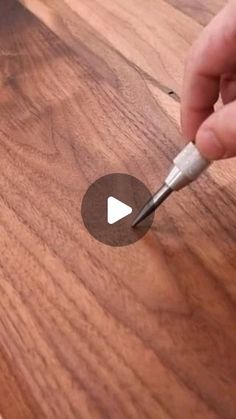 a person is using a small tool to cut the wood grain on a piece of wood