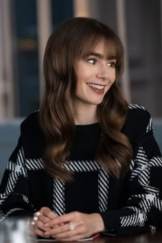 a woman with long hair sitting at a table