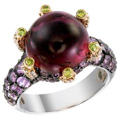 A 10.40-carat round Pink Tourmaline sits high like a colorful crystal ball on a 18k gold and palladium ring protected by 0.14-carat Yellow Diamonds. The ring’s surface is paved with 2.70-carat of Pink Sapphire and 0.59-carat of White Diamonds. This ring, as with all Zorab Creation pieces, are sent with a unique serial number to validate its authenticity. Ring Size 7 1/4 Luxury Multicolor Cabochon Rings, Luxury Round Cabochon Amethyst Ring, Luxury Amethyst Cabochon Ring For Formal Occasions, Luxury Formal Cabochon Amethyst Ring, Luxury Formal Amethyst Cabochon Ring, Elegant Multicolor Cabochon Rings, Luxury Round Gemstones For Formal Events, Luxury Round Gemstones For Formal Occasions, Multicolor Cabochon Rings For Formal Occasions