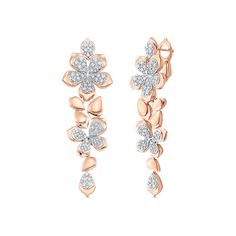 two flower shaped earrings with diamonds on each ear and one diamond in the middle, set against