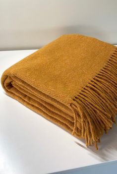 a yellow blanket folded on top of a white table