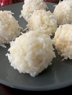 coconut balls on a plate with strawberries in the background