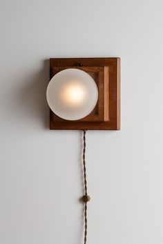 a light that is on the side of a wall with a cord attached to it