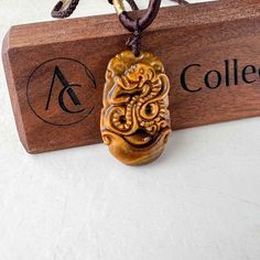 This is a Tiger Eye pendant necklace. The pendant is completely natural tiger eye, un-dyed and in its natural form. The pendant is carved in the form of the Chinese Zodiac - Snake. Size: ~1.40 x0.90 x 0.25 in. The years of the Snake include 1917, 1929, 1941, 1953, 1965, 1977, 1989, 2001, 2013, 2025, 2037... The necklace is adjustable - one size fits all. It comes with a gift box. The item is hand carved and natural so it may have imperfections because of the nature of stone or the carving. Brown Carved Amulet Necklaces, Brown Carved Pendant Necklace, Spiritual Brown Carved Necklace, Brown Carved Spiritual Jewelry, Spiritual Brown Carved Jewelry, Carved Amber Amulet Jewelry, Carved Amber Spiritual Necklaces, Carved Amber Necklace For Gift, Symbolic Carved Brown Jewelry