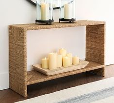 some candles are sitting on a shelf in front of a mirror with a clock above it