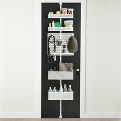 a black door with white shelves holding various items