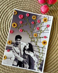 an image of a man and woman kissing in front of flowers