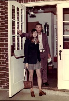 a man and woman standing in front of a door