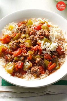 a white bowl filled with rice and meat on top of a green and white towel