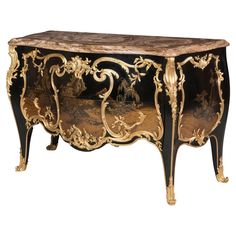 an ornately decorated cabinet with gold leaf accents and marble top in the shape of a horse