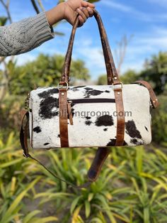 Unique black and white cowhide gym bag perfect for day trips or as a southern-style gift. Stand out with this one-of-a-kind luggage option. - Free shipping on all our cowhide weekender bags - Size: L=18" H=11" W=8.5" inches - Open with zipper closure for easy access - Adjustable and detachable sling with padded support for comfortable carrying - Inside zipper and plain compartment for organized storage - Backside zipper on the bag for additional convenience - Lower studs provided for added prote Rectangular Cow Print Travel Bag, White Leather Duffle Bag For Travel, White Leather Travel Duffle Bag, White Leather Travel Bag, Large Capacity White Leather Travel Bag, Large Capacity White Leather Weekender Bag, White Leather Rectangular Weekender Bag, White Leather Weekender Bag With Luggage Sleeve, Black And White Boho Living Room