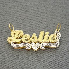 "*Junior Size Personalized Solid 10K or 14K Gold Name Pendant 3D Double Plate, carved and engraved fancy script letter font name with white tone diamond accent on bottom heart centered design and tail. *Average Name Pendant Dimension: 1 1/2 Inch (38 mm) X 5/8 Inch (15 mm) Approx. *Up to 8 Letters - Only first letter capitalized. *Thickness Top: 0.7 mm / 22 Gauge / 0.028\" Approx. *Thickness Bottom: 0.40 mm / 26 Gauges / 0.018\" Approx. *This solid gold 3D name pendant cut out by latest technolog Anniversary Nameplate Name Necklace With Hallmarks, Silver Nameplate Necklace With Diamond Accents, Engraved Diamond Nameplate Jewelry, White 14k Gold Name Necklace For Anniversary, Anniversary 14k Gold White Name Necklace, 14k Gold White Name Necklace For Anniversary, White Diamond Nameplate Jewelry, Custom Name White Gold Nameplate Jewelry, White 14k Gold Nameplate Necklace