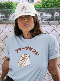 "Hand-drawn Fruit Sandwich illustration and the Japanese word \"Fruit Sandwich\" are printed on the t-shirt.  Perfect addition to your everyday outfits.   Cute to wear with matching design hat: https://www.etsy.com/listing/1383816540/fruit-sandwich-embroidered-dad-hat-fruit?click_key=c3c61617d23471b117340458a359d4d3998914ad%3A1383816540&click_sum=473181f3&ref=shop_home_active_14&frs=1 ♡Product Details♡ * 100% combed and ring-spun cotton * Athletic Heather - 90% combed and ring-spun cotton, 10% polyester * Heather Peach -  52% combed and ring-spun cotton, 48% polyester * Fabric weight: 4.2 oz/yd² (142 g/m²) * Pre-shrunk fabric * Side-seamed construction * Shoulder-to-shoulder taping ♡Sizes♡ Unisex sizes. Classic fit. Go up one or two sizes if you want an oversize. ♡Care Instructions♡ Machin Kawaii T-shirt With Funny Print And Crew Neck, Kawaii Funny Print Crew Neck T-shirt, Kawaii Crew Neck T-shirt With Relaxed Fit, Kawaii Graphic Print T-shirt With Relaxed Fit, Kawaii Crew Neck Pre-shrunk Top, Kawaii Pre-shrunk Short Sleeve T-shirt, Kawaii Short Sleeve Pre-shrunk T-shirt, Kawaii Crew Neck Pre-shrunk T-shirt, Sandwich Illustration