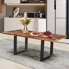 a wooden table with two plates of fruit on it in front of a white kitchen