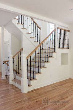 an empty living room with hardwood floors and stairs