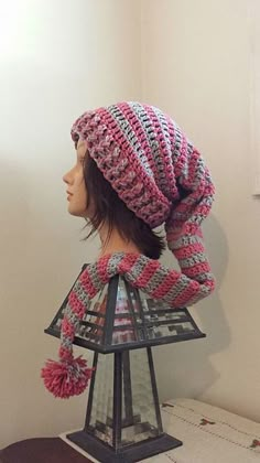 a mannequin head wearing a pink and white knitted hat