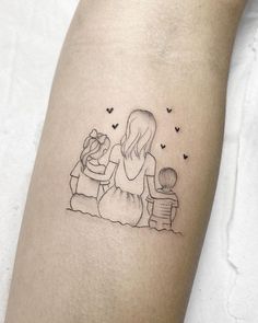 a small tattoo on the arm of a woman with a little boy sitting next to her