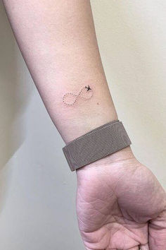 a person's arm with a small tattoo on the left side of their wrist