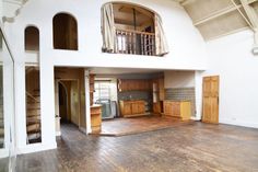 an empty living room with wood floors and white walls