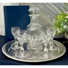 an empty glass decanter and wine glasses on a tray