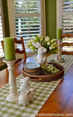 a dining room table set for easter with candles and bunny figurines on it