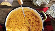 a bowl of macaroni and cheese with a spoon in it on a table