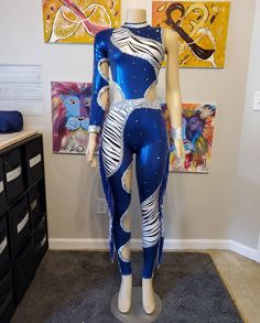 a mannequin dressed in blue and white is standing next to some art work