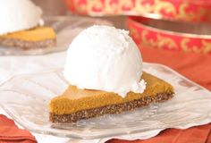 a slice of pumpkin pie topped with whipped cream on a glass plate next to another piece of pie