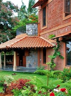 the house is surrounded by lush green plants and flowers in front of it's windows