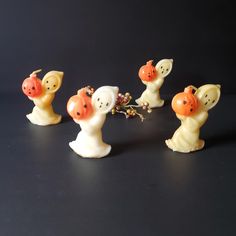 four little figurines are arranged in the shape of animals with orange beaks