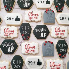 decorated cookies with names and dates are displayed on a table in front of the wall