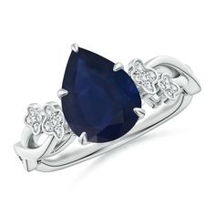 an oval shaped blue sapphire and diamond ring with two diamonds on each side, set in 18k white gold