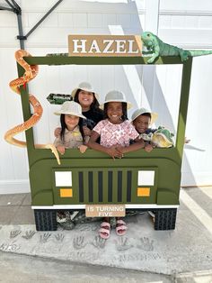 three children are sitting in the back of a truck with a sign that says hazel