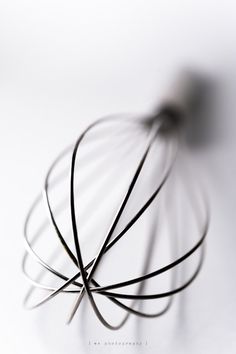 a metal whisk on a white surface