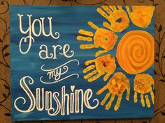 a painted sign that says you are my sunshine with handprints on the sun