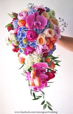 a bouquet of flowers is held up by someone's hand on a white background