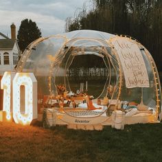 an inflatable tent is set up on the grass with lights around it and a sign that reads 10