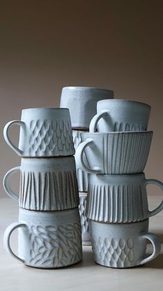 four white cups stacked on top of each other