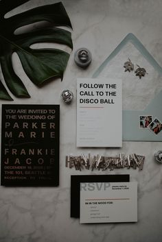 the wedding stationery is laid out neatly on top of the marble table, including brochures and pins