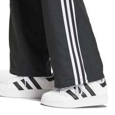 Wide legs make for comfortable days... The adidas Wide Leg Women's Cargo Pants give you plenty of room to move, along with handy cargo pockets to store your belongings. And with the iconic adidas stripes down the side, you can get the comfort and classic style the brand is known for.Features adidas three-stripe design. Relaxed fit. Elastic waistband. Features two cargo pockets. Material: 100% Polyester. Consists of at least 40% recycled materials. Contains 50% Parley Ocean Plastic. Women's Cargo Pants, Adidas Three Stripes, Back To School Backpacks, Adidas Tee, Black And White Sneakers, Move Along, Cargo Pant, Cargo Pants Women, Nike Tees