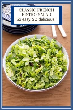 a bowl filled with lettuce sitting on top of a table next to plates