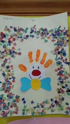 a paper plate with handprints and confetti on it