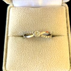 a diamond ring sitting on top of a cushioned surface in a box with the lid open