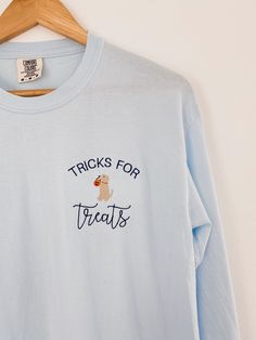 What's cuter than your favorite golden?! He will do tricks for treats! This design is embroidered on your choice of a Comfort Colors long sleeve or crewneck sweatshirt! It is unisex sized. This means the sizing is boxy, not fitted like women's, but it is not oversized. It is true to size. I do not accept returns, cancellations, or exchanges. Please triple check all details (including address) before you place your order. Cute Long Sleeve T-shirt With Embroidered Text, Custom Embroidered Long Sleeve Top For Halloween, Cute Long Sleeve Embroidered T-shirt, Cute Custom Embroidered Tops For Fall, Cute Tops With Custom Embroidery For Fall, Halloween Embroidered Long Sleeve Tops, Cute Embroidered Text Tops For Fall, Cute Tops With Embroidered Text For Fall, Blue Embroidered T-shirt For Fall