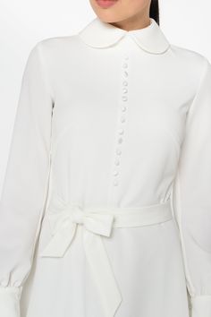 "A collared midi dress featuring a button front closure (imitation), fabric belt, and a fit and flare silhouette. - fit and flare silhouette - high rounded collar - knee length (midi) - long sleeves with cuffs - fabric belt - covered button front decor - concealed zipper closure - lined bodice and skirt - color: white Fiber: 60% viscose, 35% polyester, 5 % elastane, Lining - 95 % viscose, 5% elastane. For size S:dress length- 40,0 \" (102 cm), sleeve length 24,21\" (61,5 cm) Our model wears size Classic A-line Midi Dress For Wedding, Cream Midi Dress For Wedding Guest, Elegant A-line Dress With Covered Buttons, Cream Lace Midi Dress For Wedding, Chic A-line Long Sleeve Wedding Dress, White Long Sleeve Midi Dress For Semi-formal Occasions, White Long Sleeve Maxi Dress For Formal Occasions, White Long Sleeve Formal Maxi Dress, Classic A-line Maxi Dress For Wedding