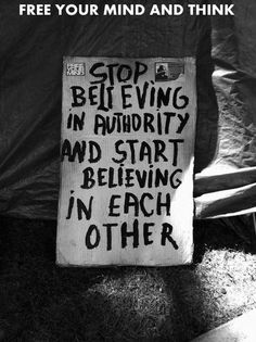 a sign that reads stop believing in authority and start believing in each other