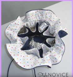 a close up of a flower shaped object on a white surface with polka dots and blue trim